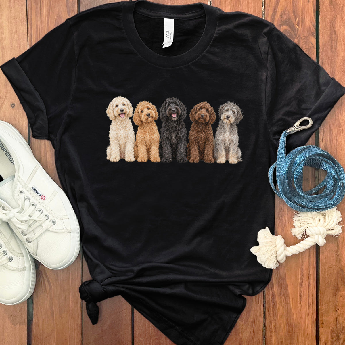 Black t-shirt with a graphic of five fluffy dogs in varying colors sitting in a row.