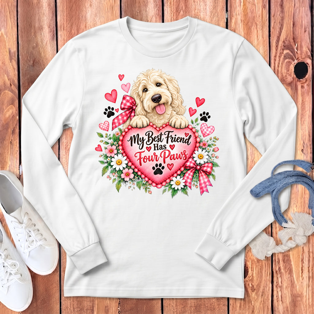 White long-sleeve t-shirt featuring a doodle dog resting on a pink heart with the text My Best Friend Has Four Paws surrounded by flowers and hearts.
