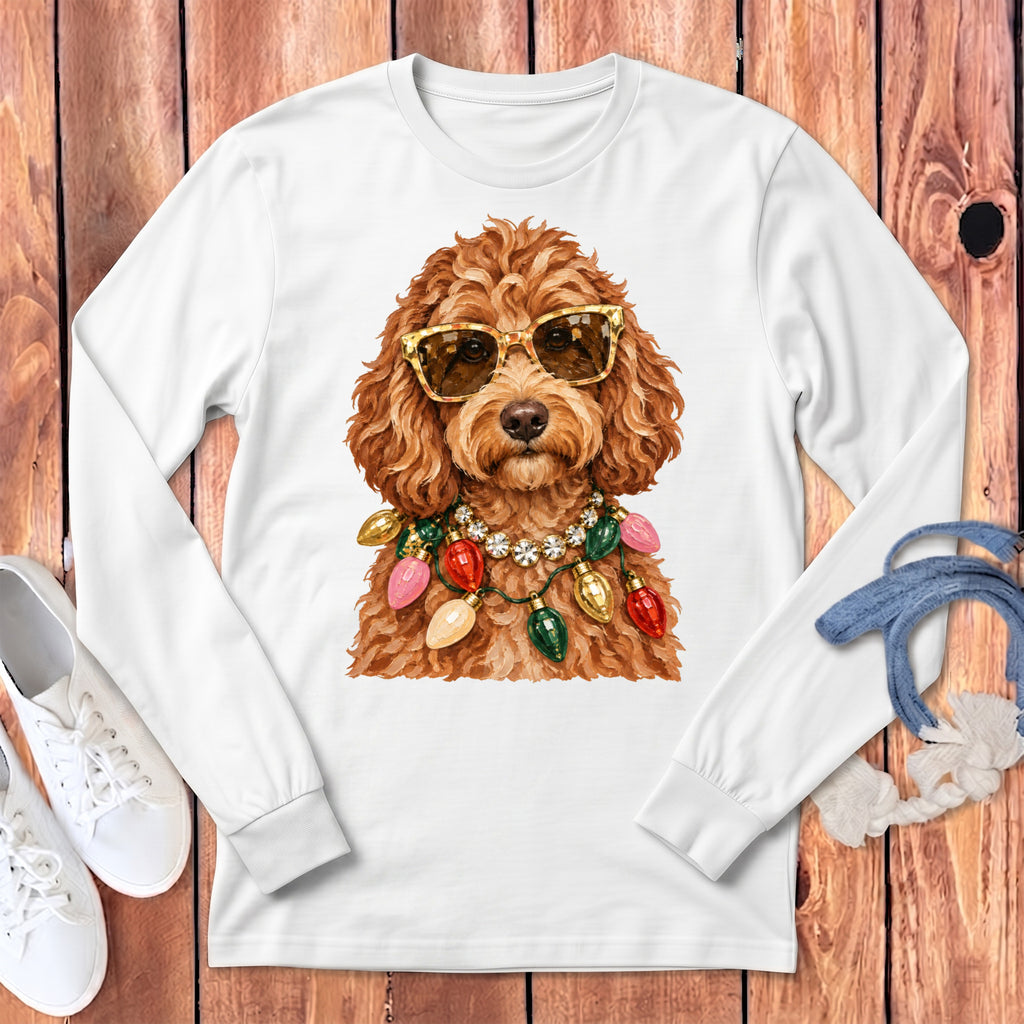 Brown poodle wearing sunglasses and a Christmas light necklace on a white long-sleeved shirt.