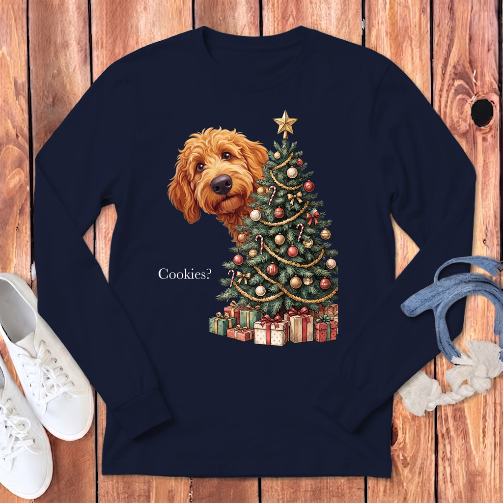 Goldendoodle dog peeks from behind a decorated Christmas tree with presents, asking "Cookies?".
