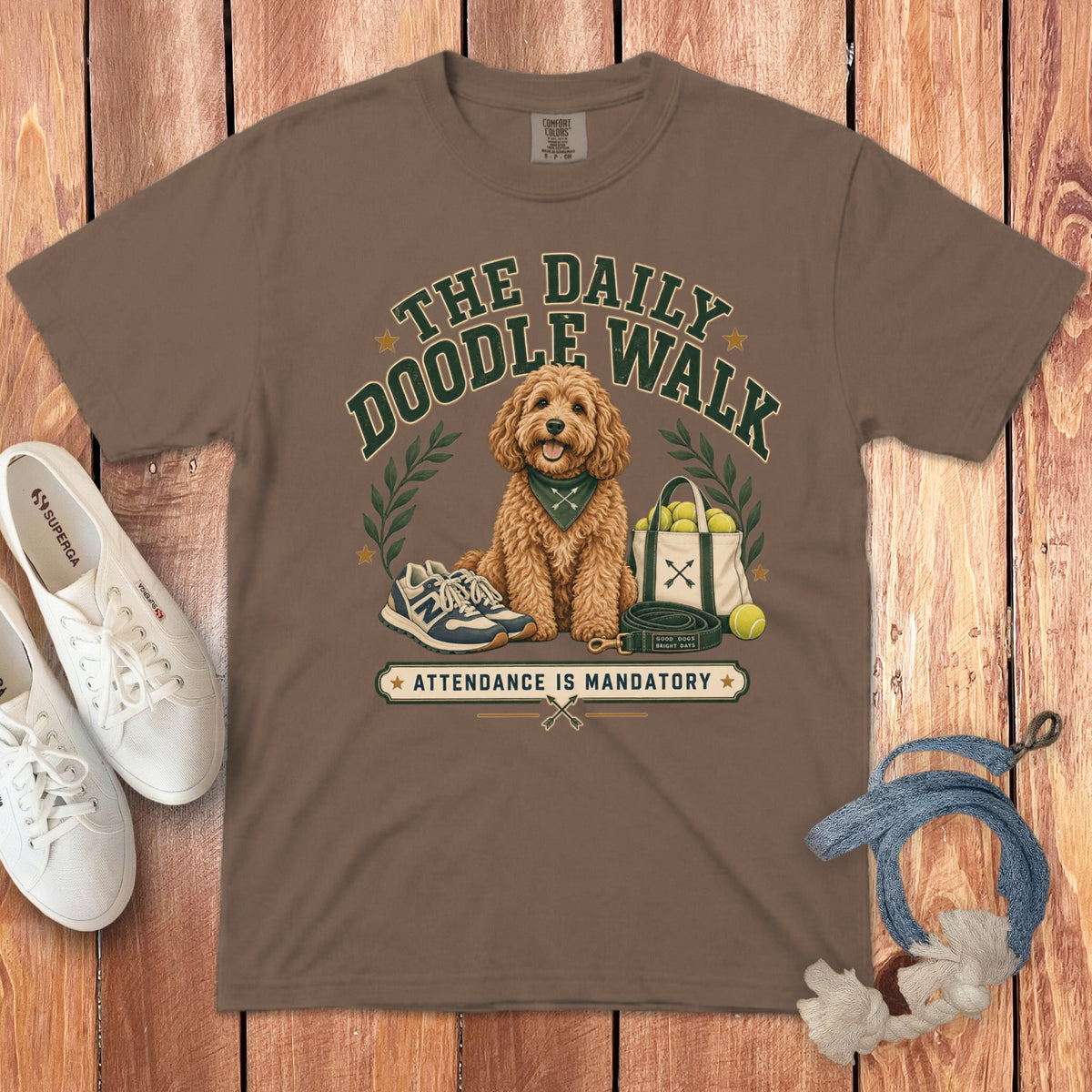 Brown t-shirt with illustration of a doodle dog, "The Daily Doodle Walk" text, and "Attendance is Mandatory" banner.