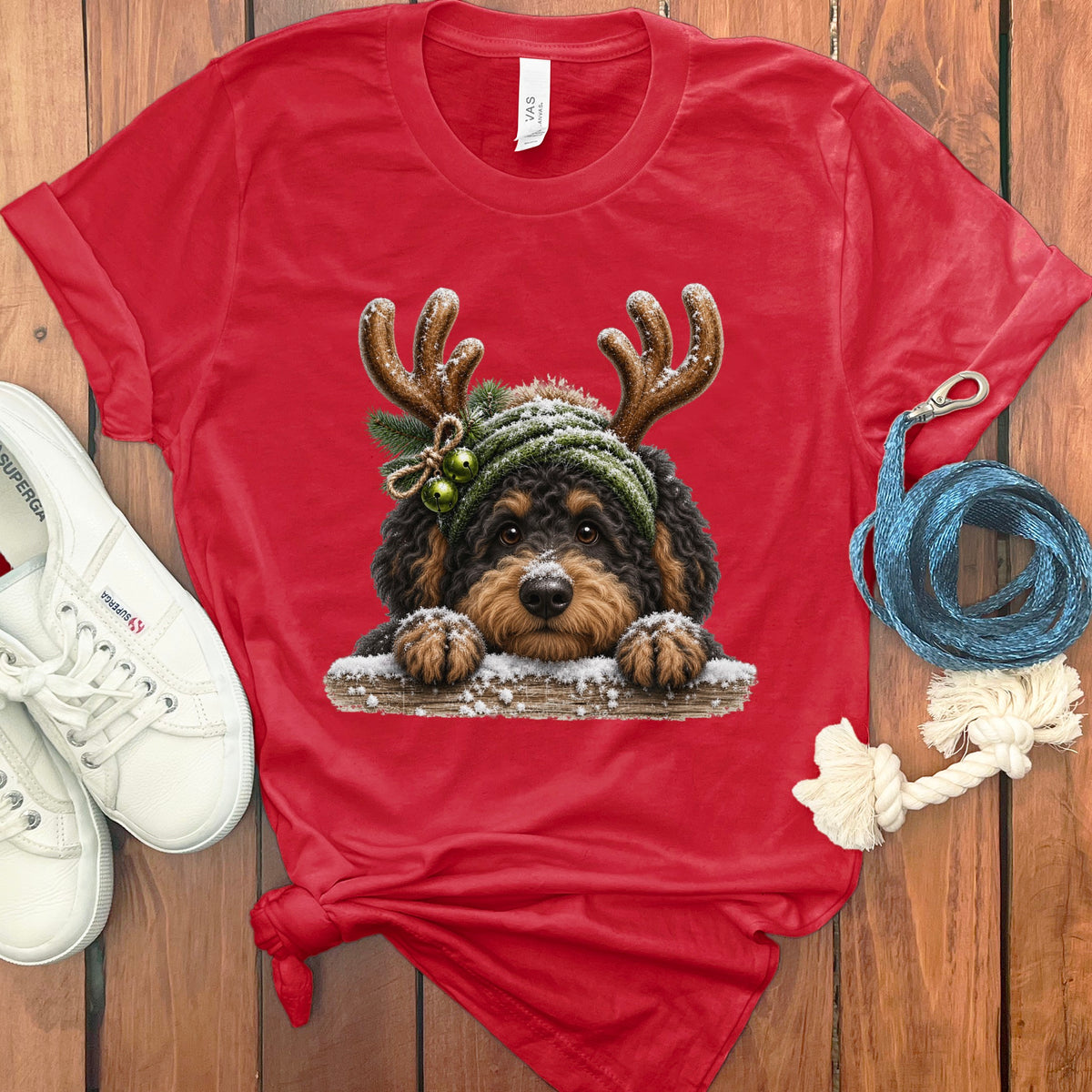 Red t-shirt with a digitally printed image of a dog wearing reindeer antlers and a beanie.