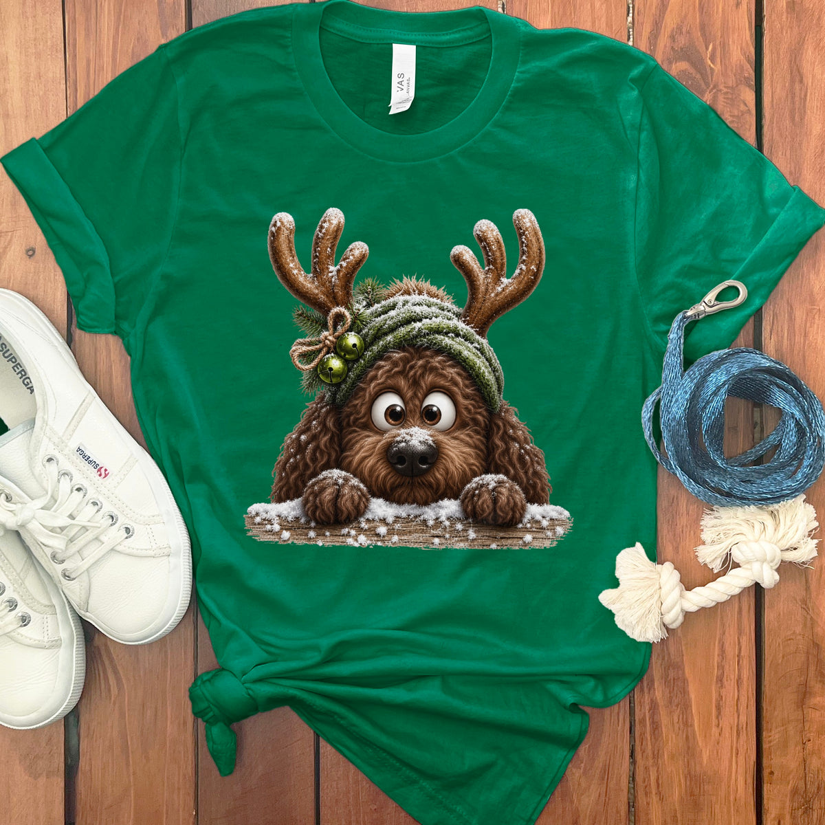 Green t-shirt with a brown dog wearing reindeer antlers and a winter hat.