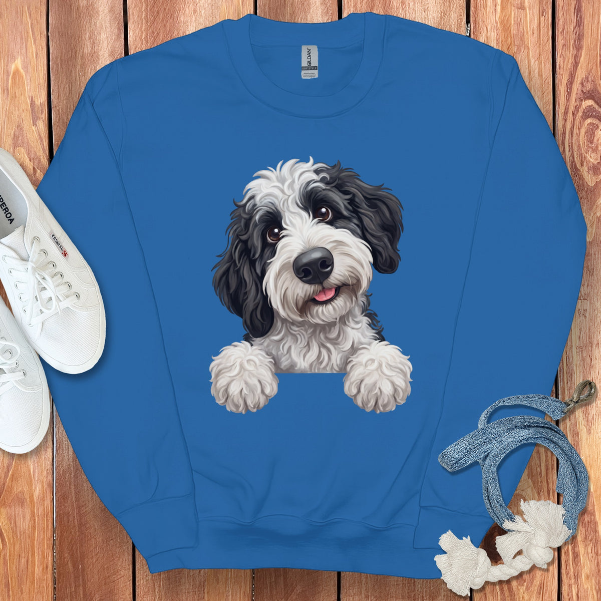 Blue sweatshirt with a printed black and white fluffy dog peeking over the collar.