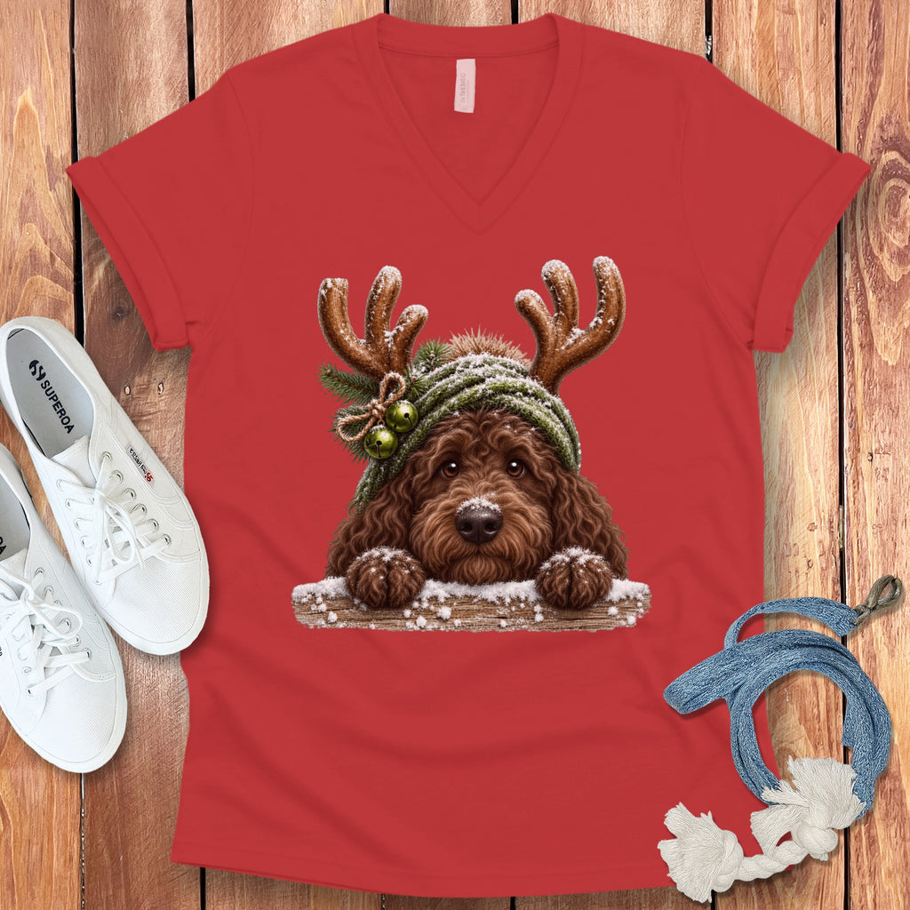 Brown doodle dog wearing reindeer antlers and a green beanie with bells.