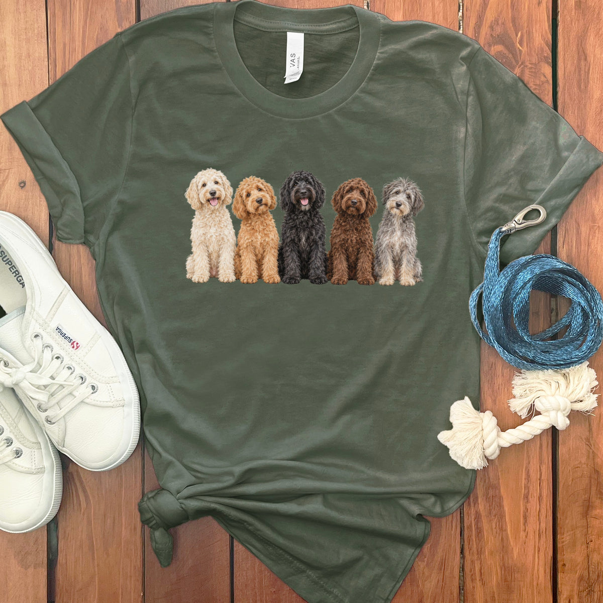 Olive green t-shirt with a graphic of five doodles in varying colors.
