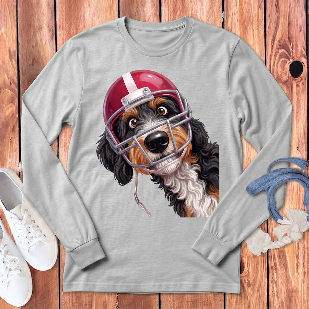 Bernedoodle dog wearing a red and white football helmet and facemask.