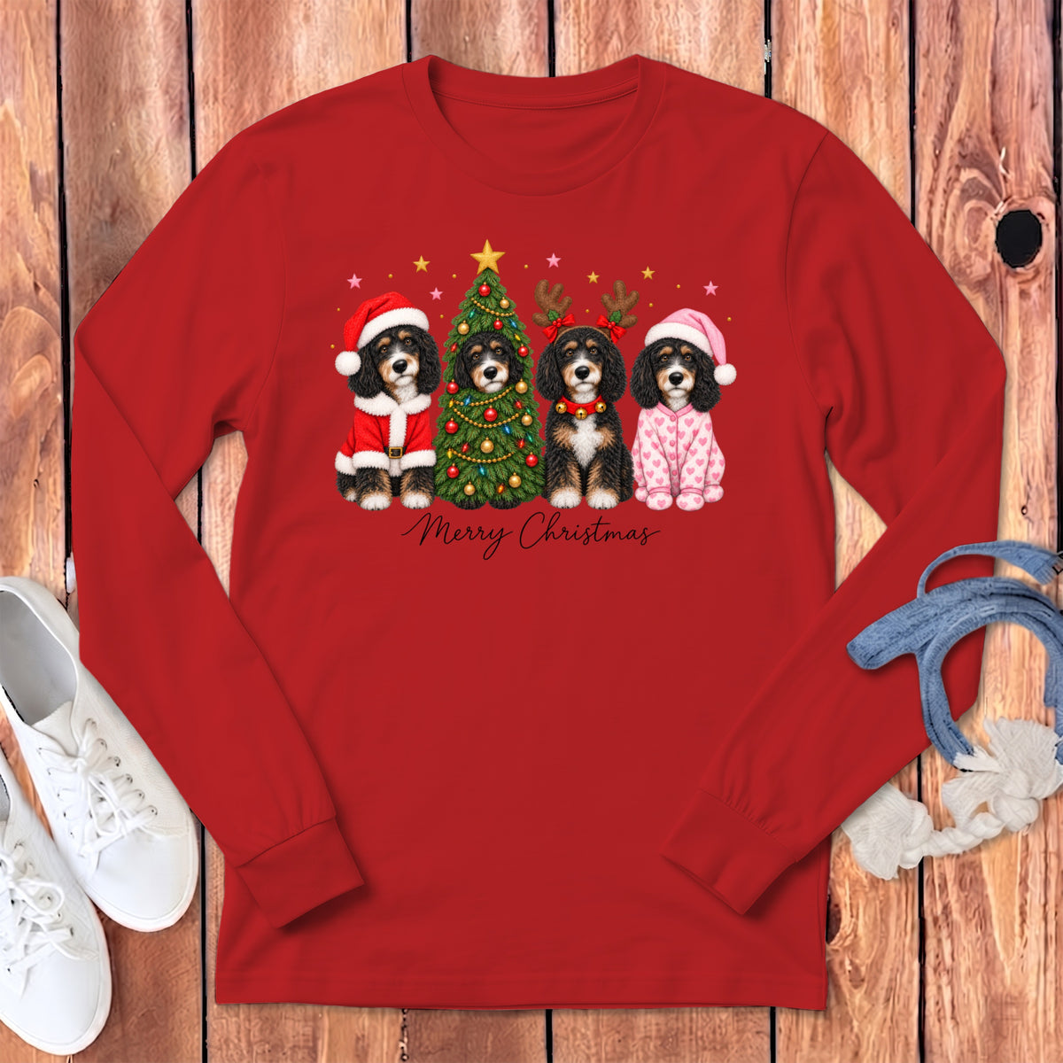 Red long-sleeved shirt featuring four dogs dressed in holiday costumes surrounding a Christmas tree.