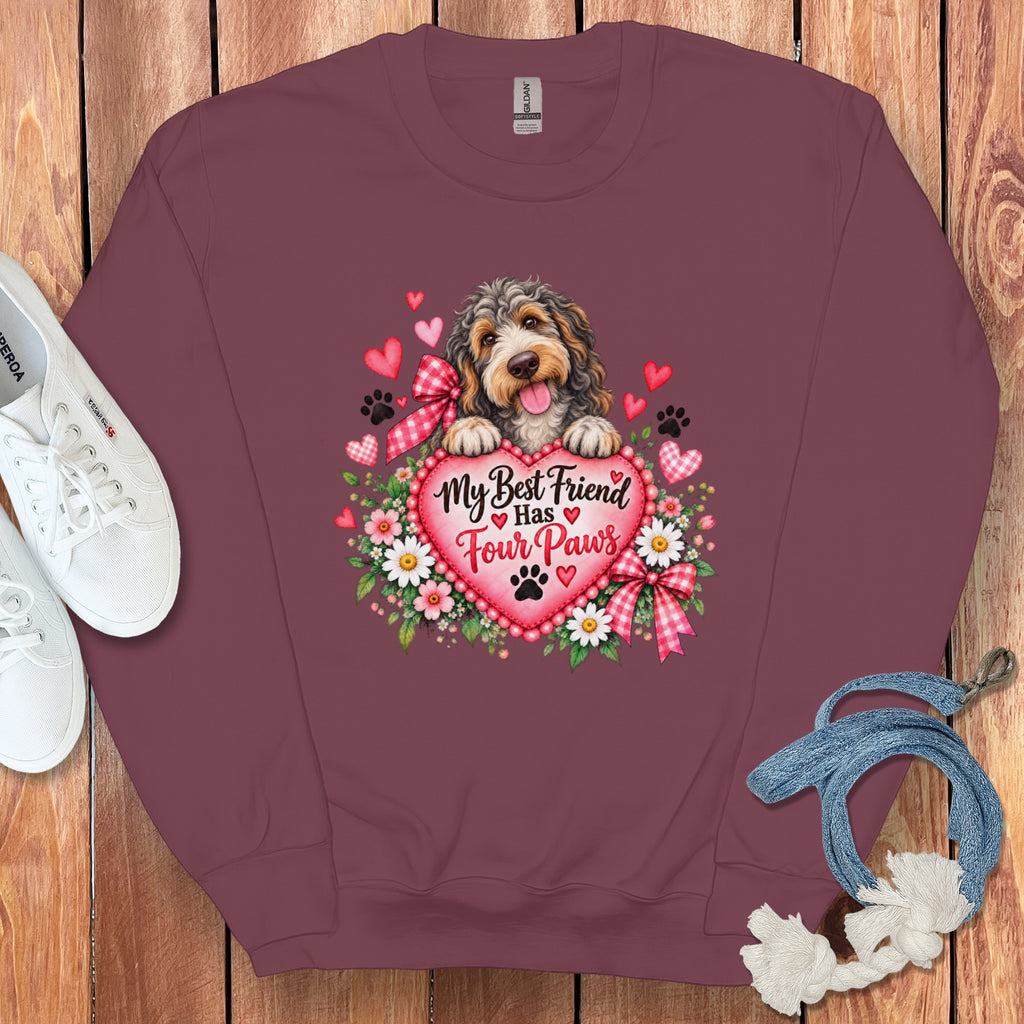 Maroon crewneck sweatshirt featuring a puppy holding a pink heart with the text My Best Friend Has Four Paws, surrounded by flowers, hearts, and paw prints.