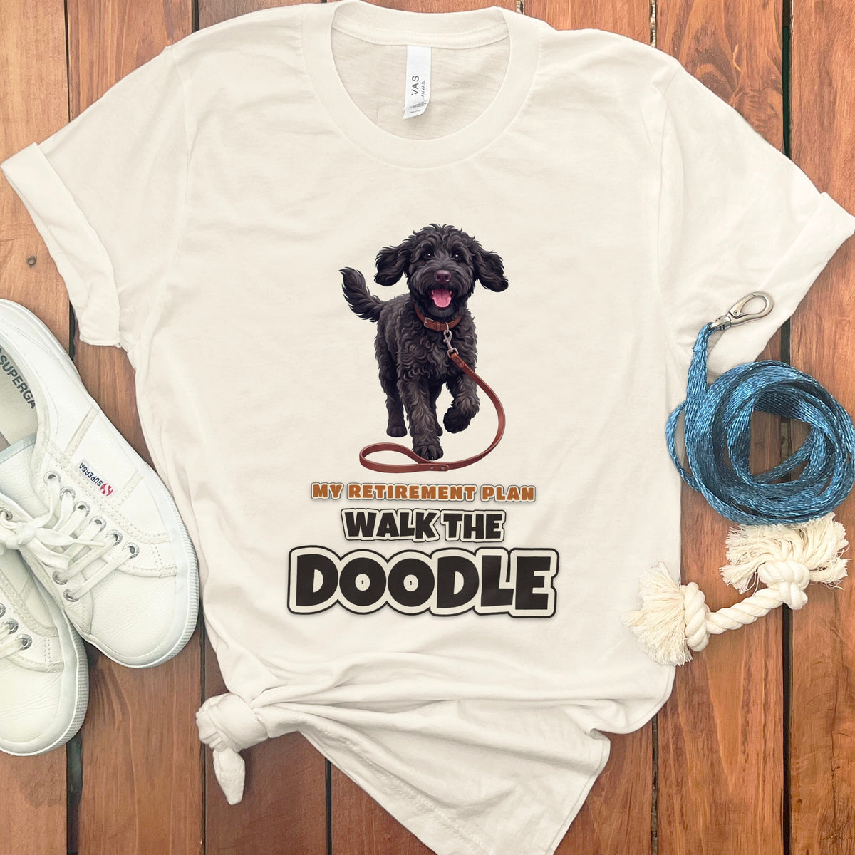 Cream t-shirt with a black doodle walking on a leash and text "MY RETIREMENT PLAN WALK THE DOODLE".