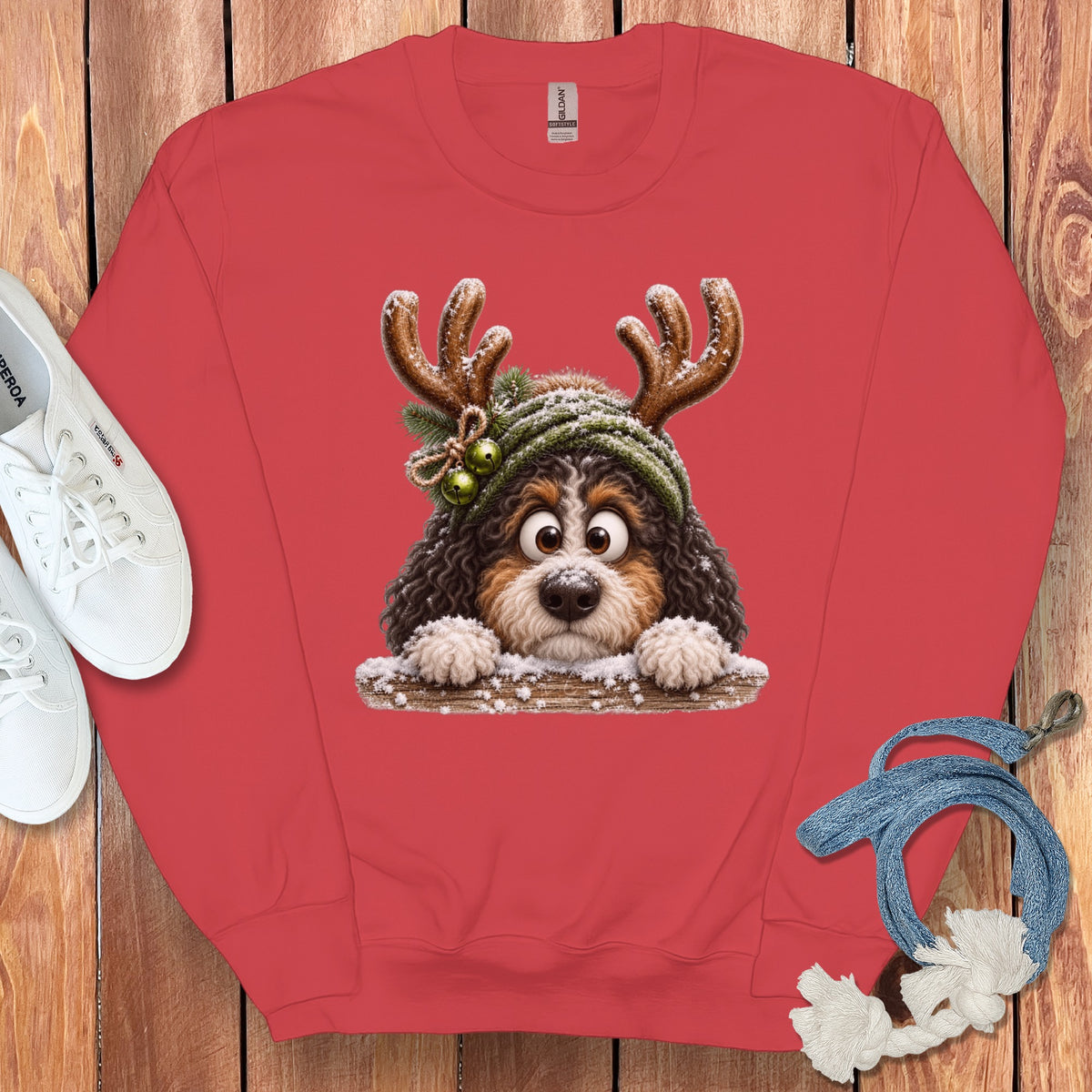 Coral sweatshirt with a cartoon Bernese Mountain Dog wearing antlers and a hat.
