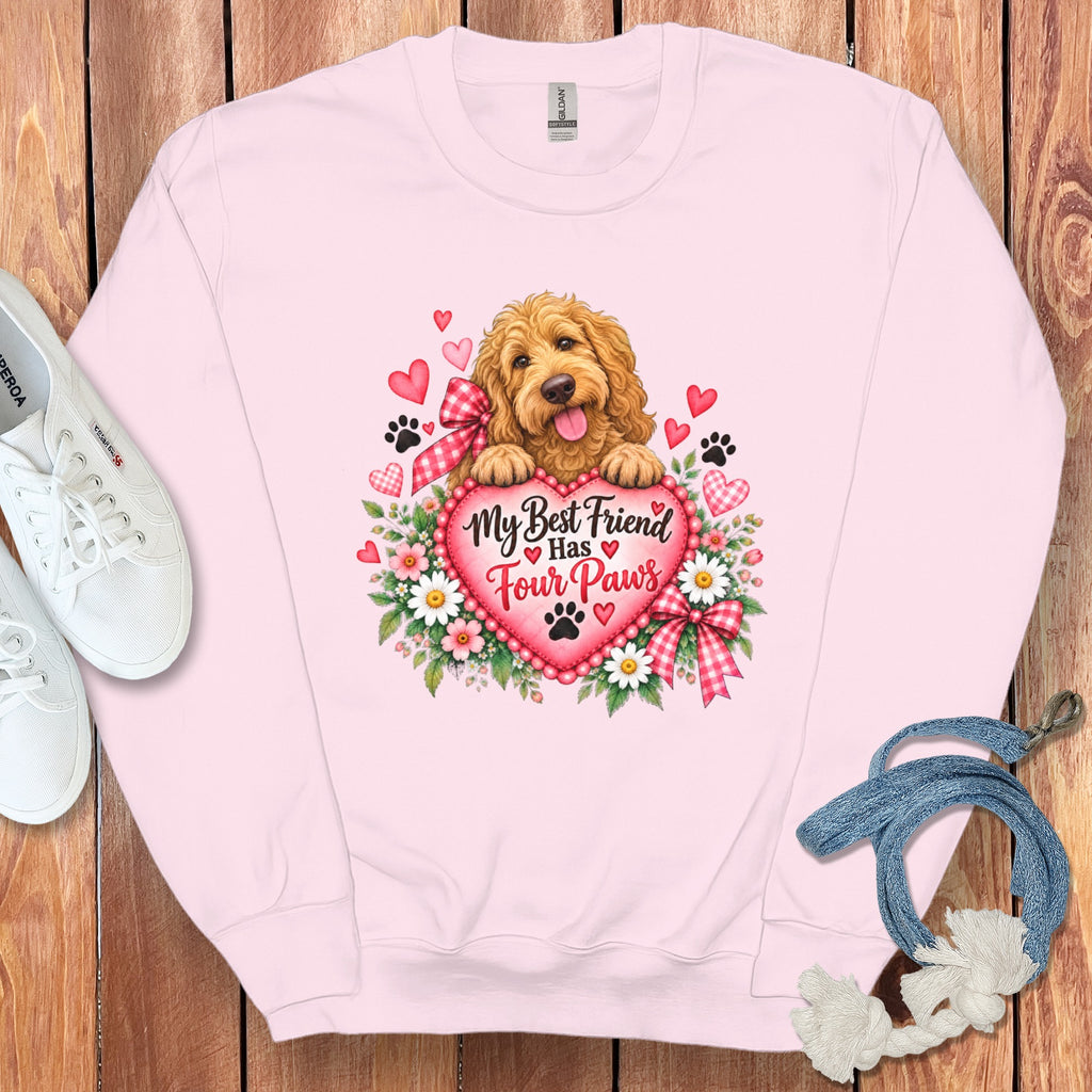 Light pink crewneck sweatshirt featuring a graphic of a golden doodle resting on a heart with text reading My Best Friend Has Four Paws.