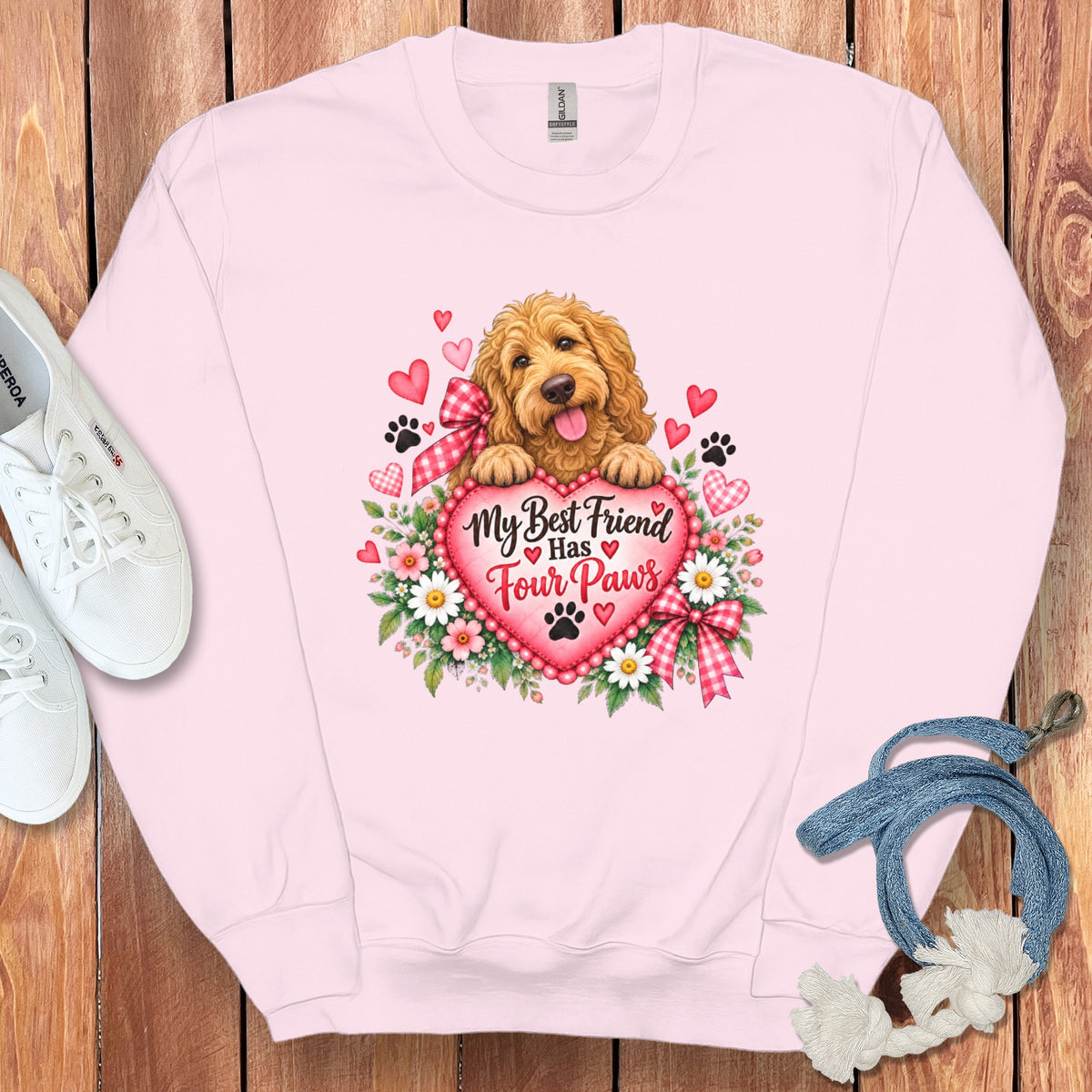 Light pink crewneck sweatshirt featuring a graphic of a golden doodle resting on a heart with text reading My Best Friend Has Four Paws.