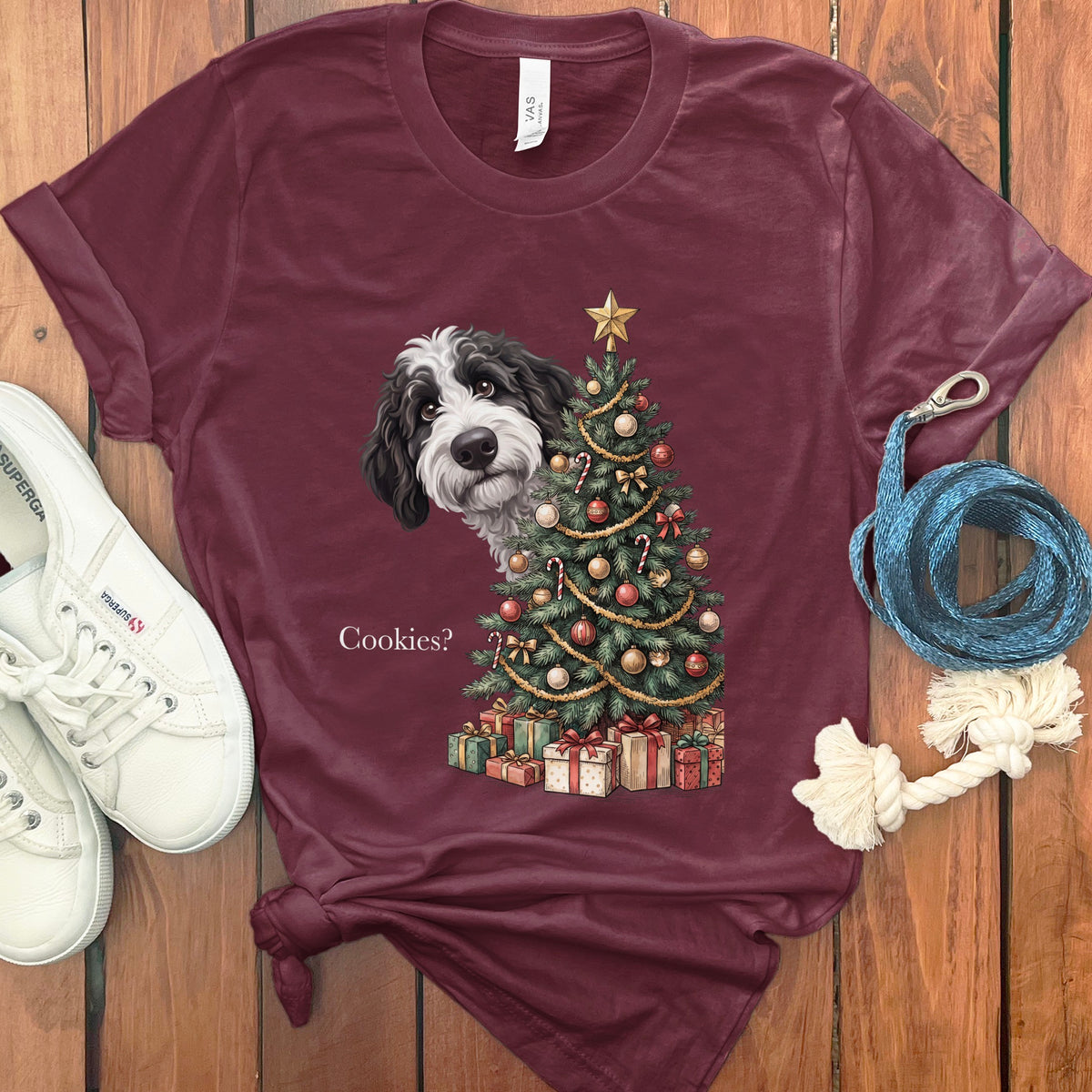 Maroon t-shirt with a dog peeking by a Christmas tree that says "Cookies?"
