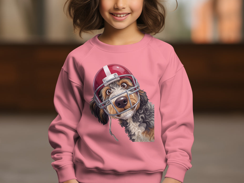 Dog wearing a football helmet graphic on a pink crewneck sweatshirt.
