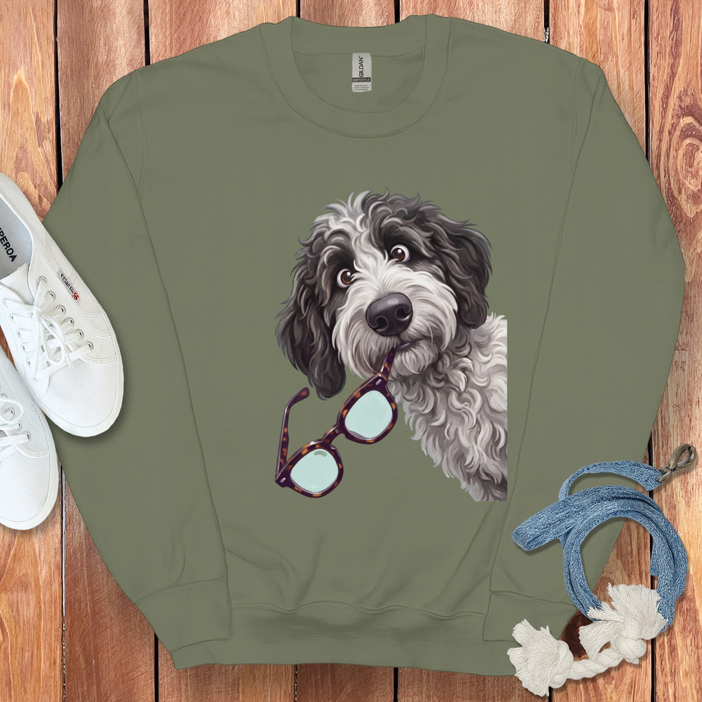 Olive green crewneck sweatshirt featuring a graphic of a shaggy doodle dog holding tortoise shell glasses.