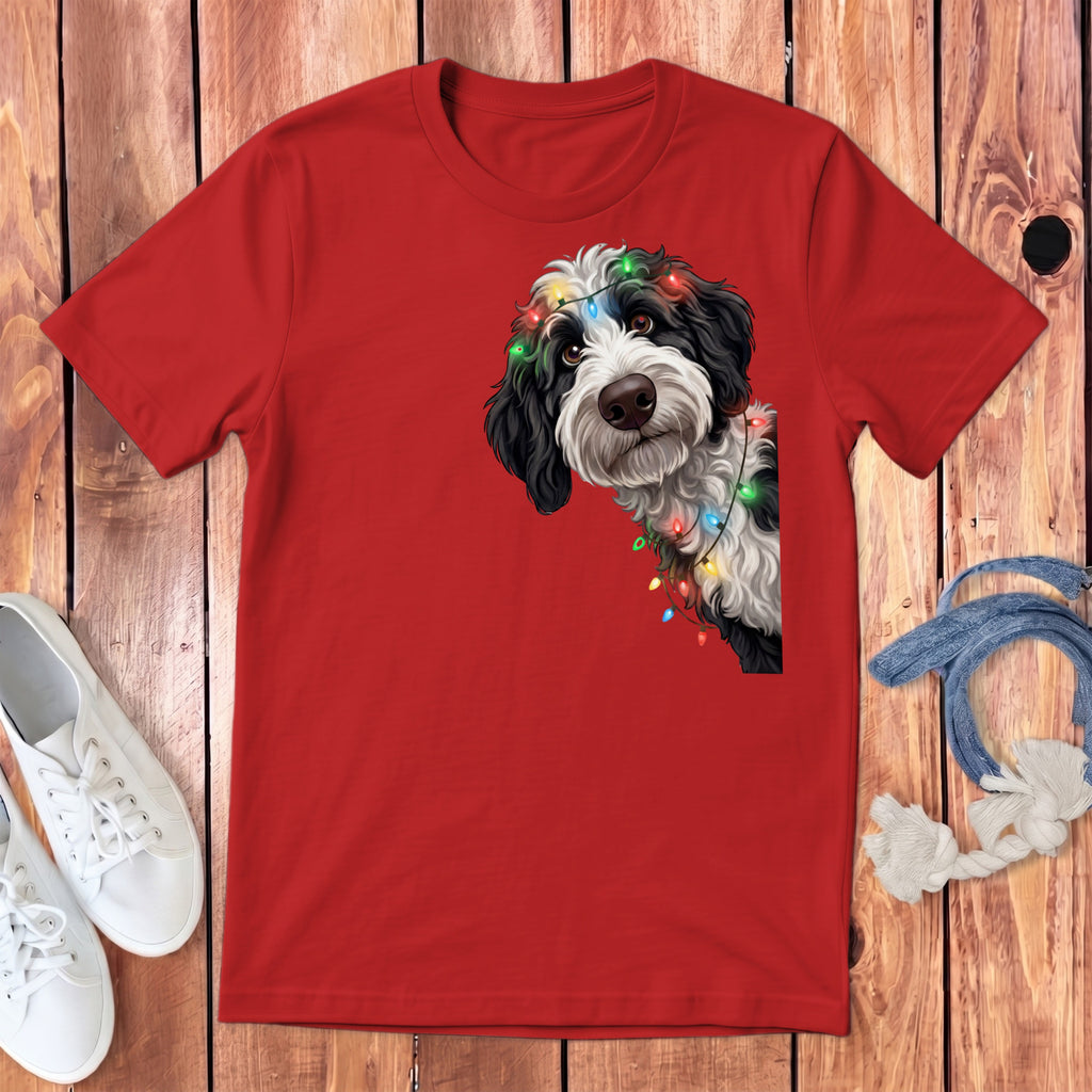 Red t-shirt with a black and white dog wearing colorful Christmas lights.
