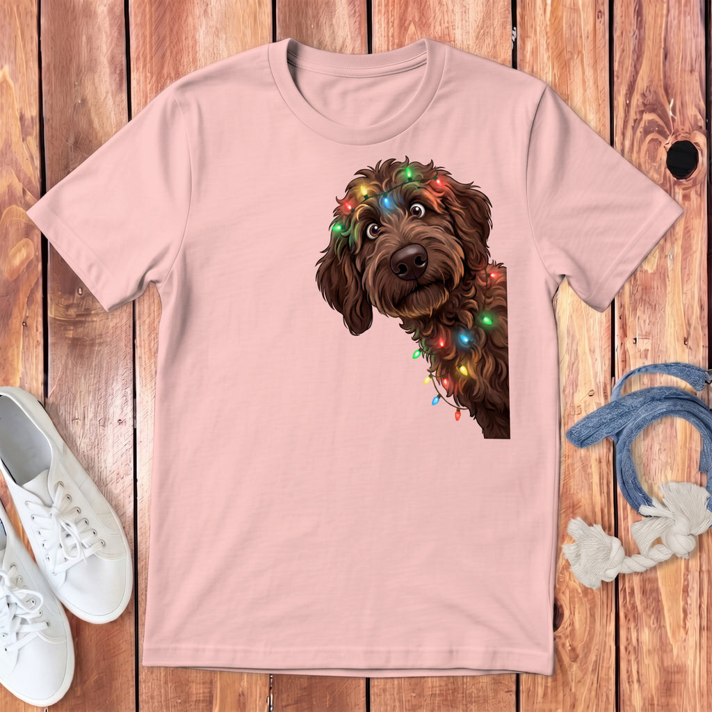 Pink t-shirt with brown dog wearing colorful Christmas lights graphic.