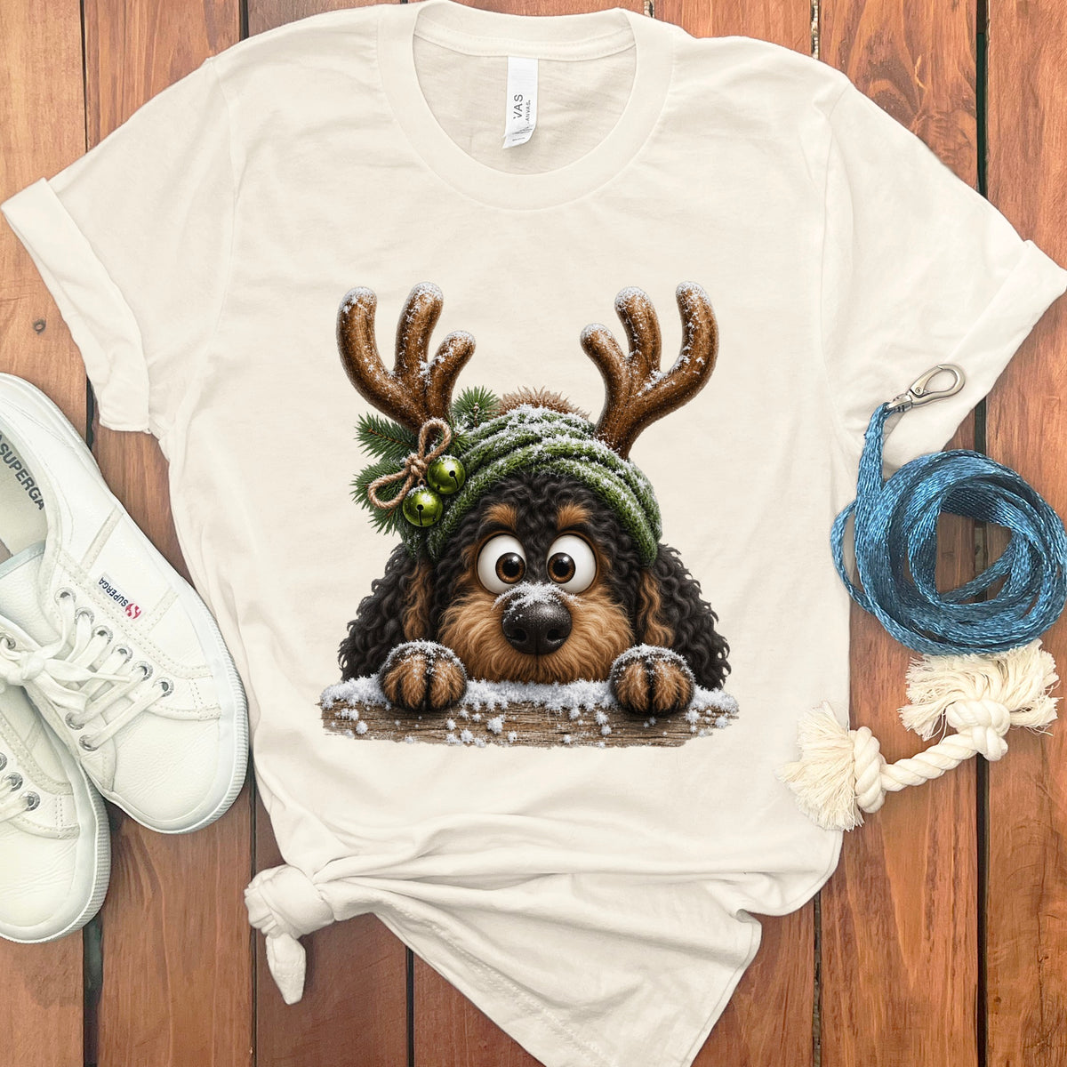 T-shirt with a cartoon dog wearing reindeer antlers and a green knit hat.