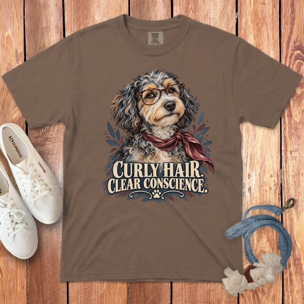 Brown t-shirt featuring a graphic of a curly-haired dog wearing glasses and a maroon scarf, with text reading "CURLY HAIR, CLEAR CONSCIENCE."