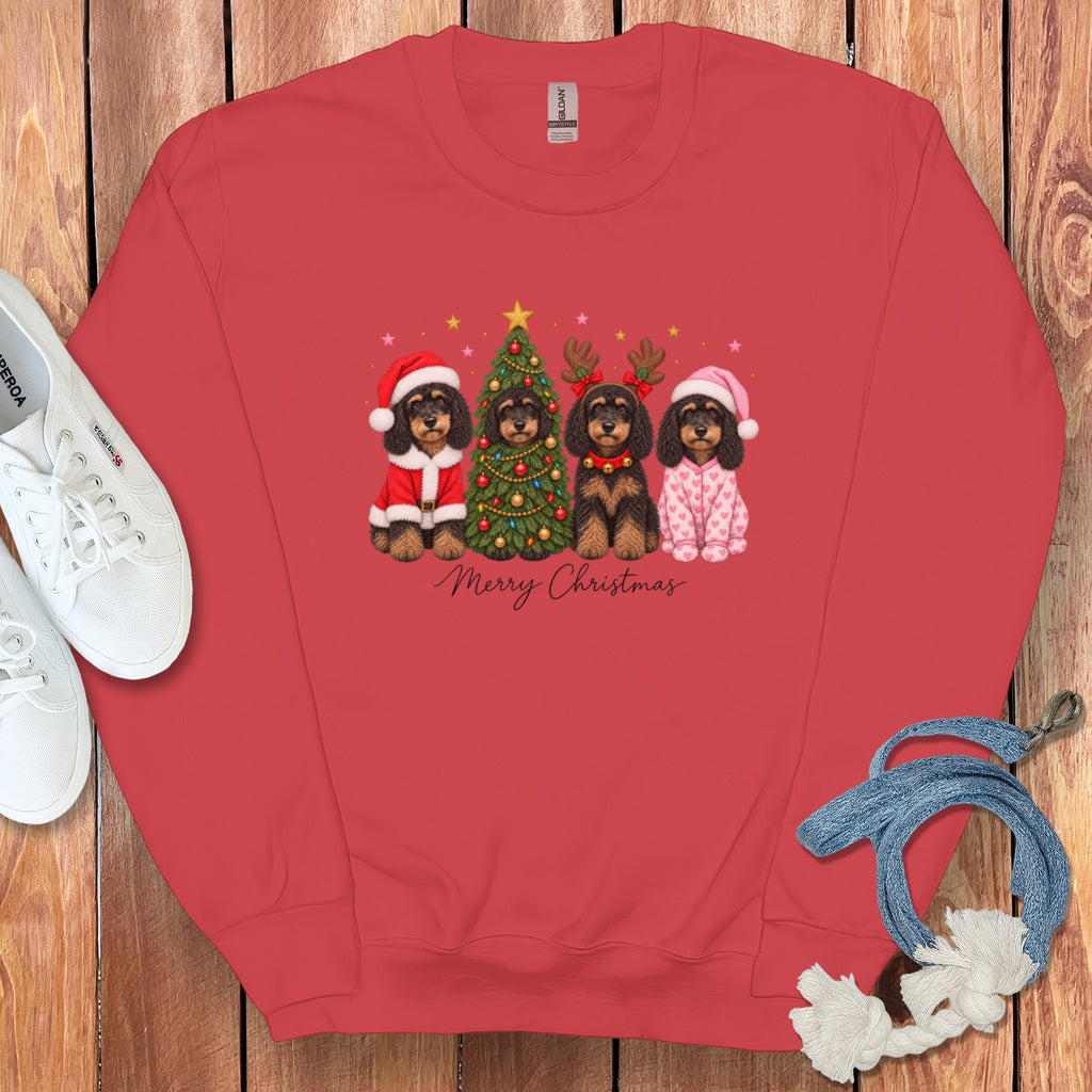 A red crewneck sweatshirt with a graphic of four dogs celebrating Christmas, text reading Merry Christmas, and white sneakers and a blue rope on a wooden background.