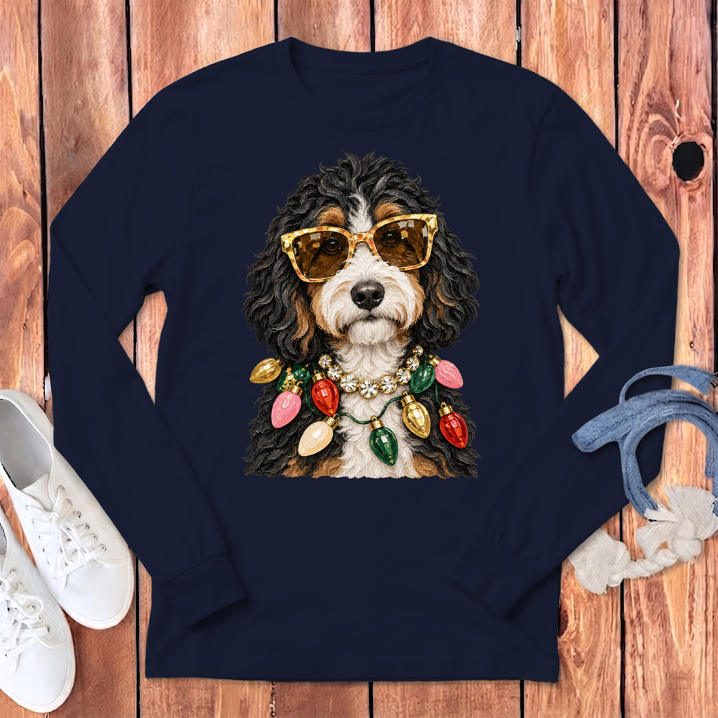 Bernese Mountain Dog wearing sunglasses and Christmas lights necklace on navy shirt.