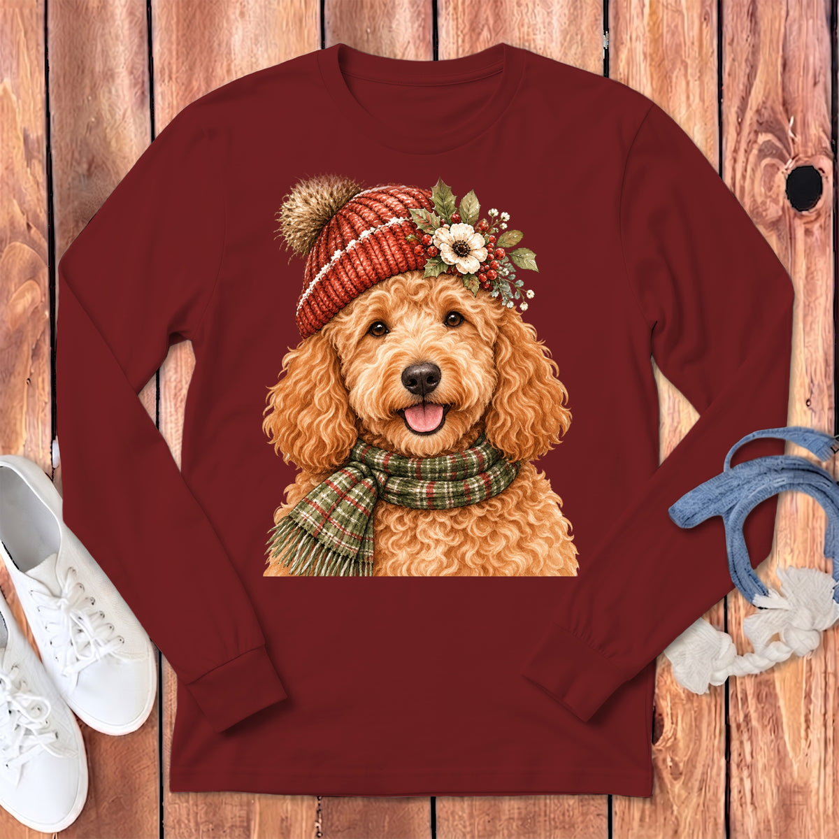 Goldendoodle dog wearing a knitted hat and plaid scarf, printed on a maroon long-sleeve shirt.