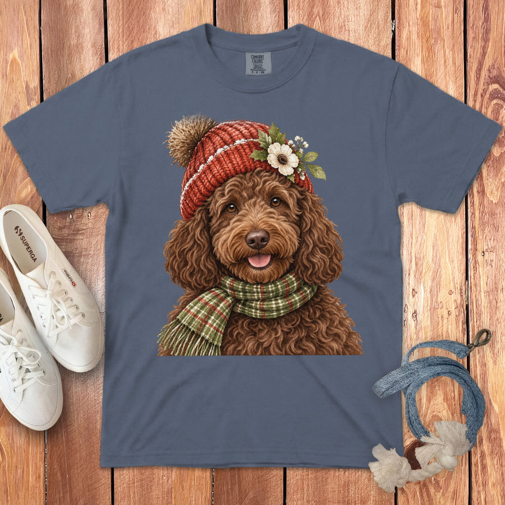 Blue t-shirt with a brown doodle wearing a red beanie and green plaid scarf.