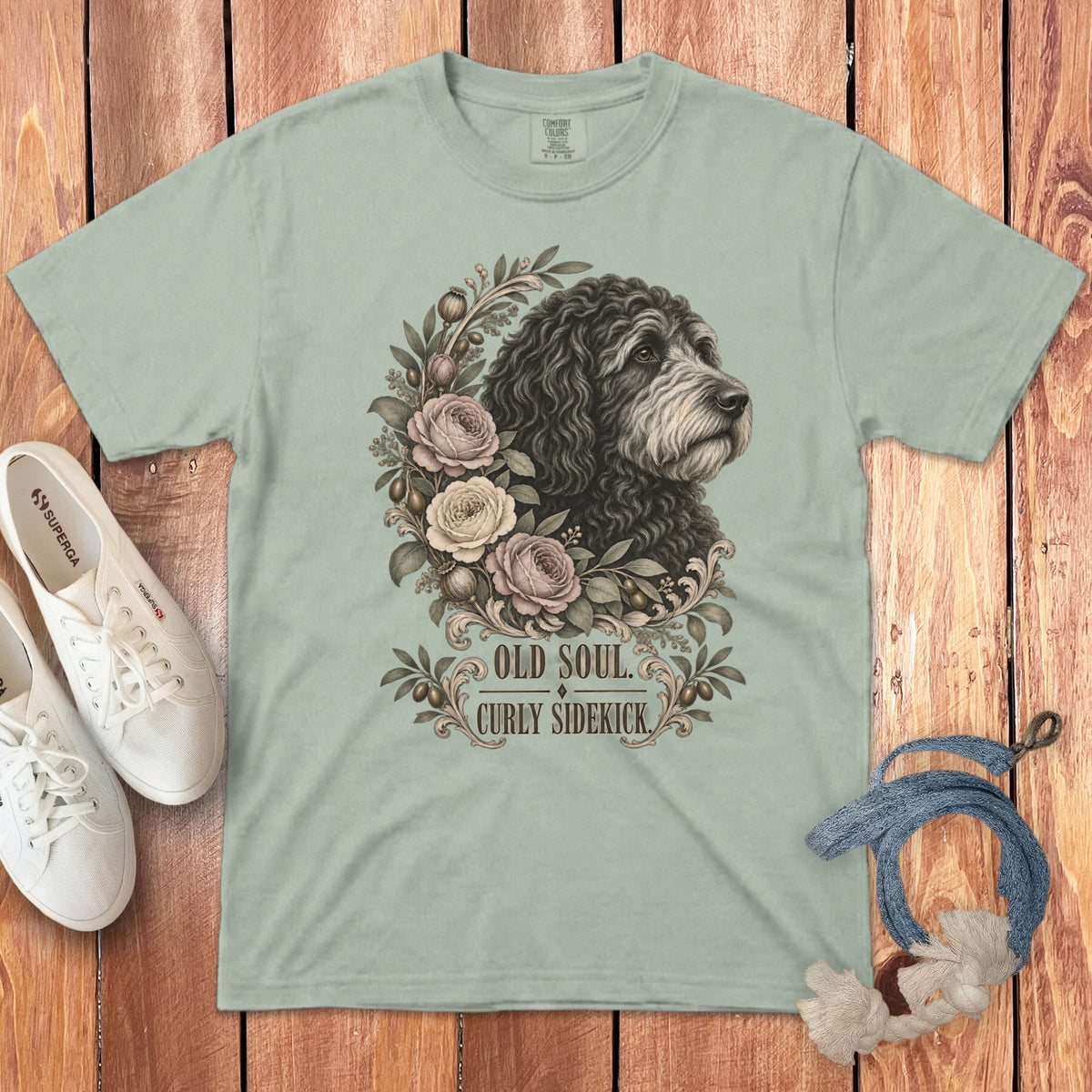 Sage green t-shirt featuring a vintage illustration of a curly-haired dog surrounded by roses and foliage, with the text OLD SOUL CURLY SIDEKICK.