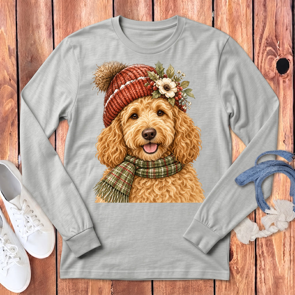 Golden doodle wearing a winter hat and scarf, shown on a light gray long-sleeve shirt.