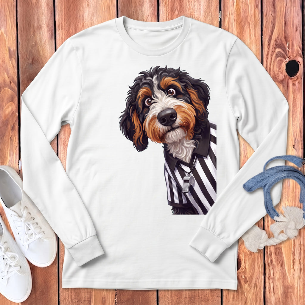Bernedoodle dog wearing referee shirt and whistle on white long sleeve shirt.