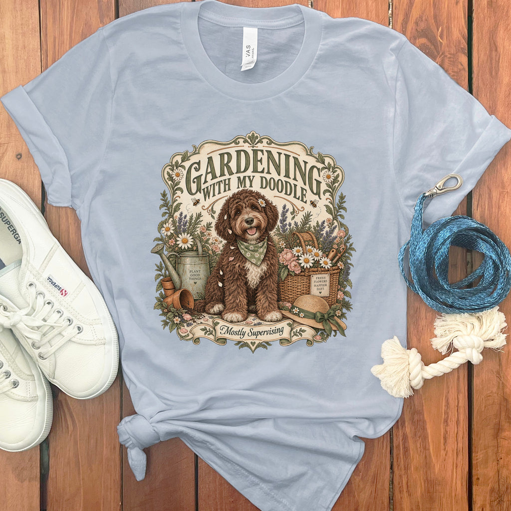 Light blue t-shirt with a graphic of a dog gardening, text reads "Gardening with my Doodle".