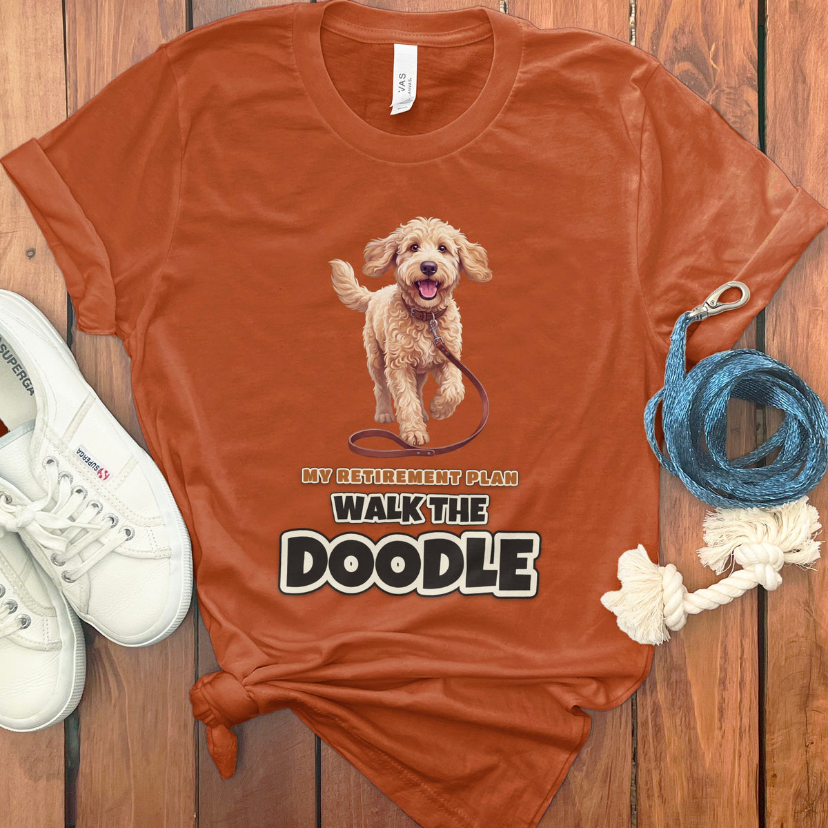 Orange t-shirt with doodle graphic and text "My Retirement Plan Walk the Doodle".