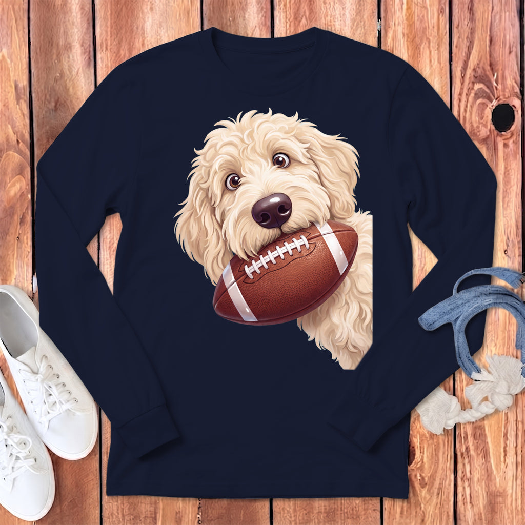 Fluffy dog with a football in its mouth on a navy long-sleeve shirt.