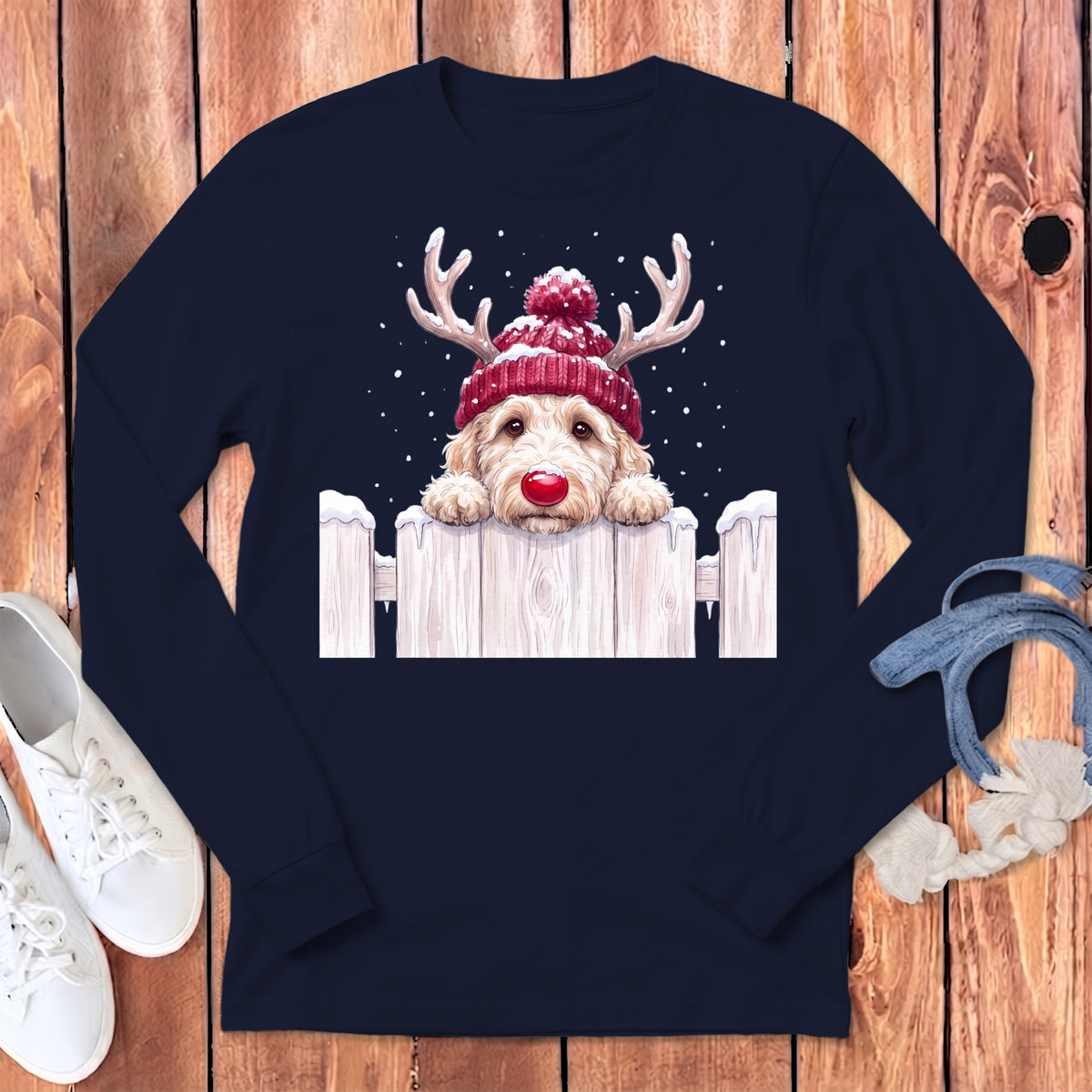 Golden doodle dog wearing a red knit hat with antlers and a red nose.