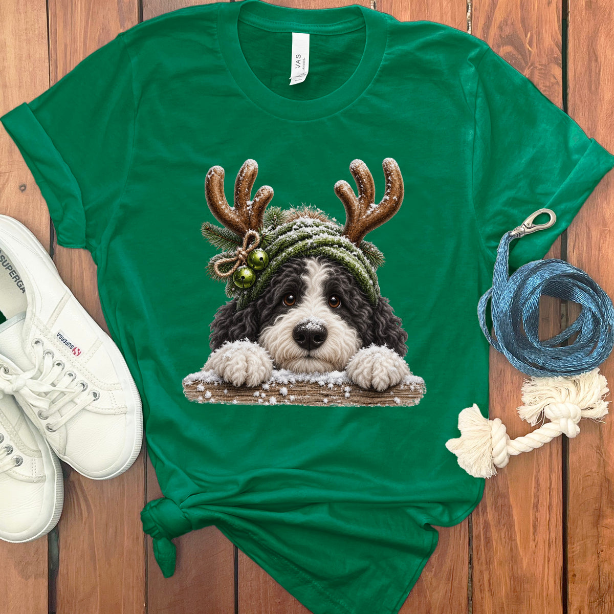 Green t-shirt with a dog wearing reindeer antlers and a festive hat.