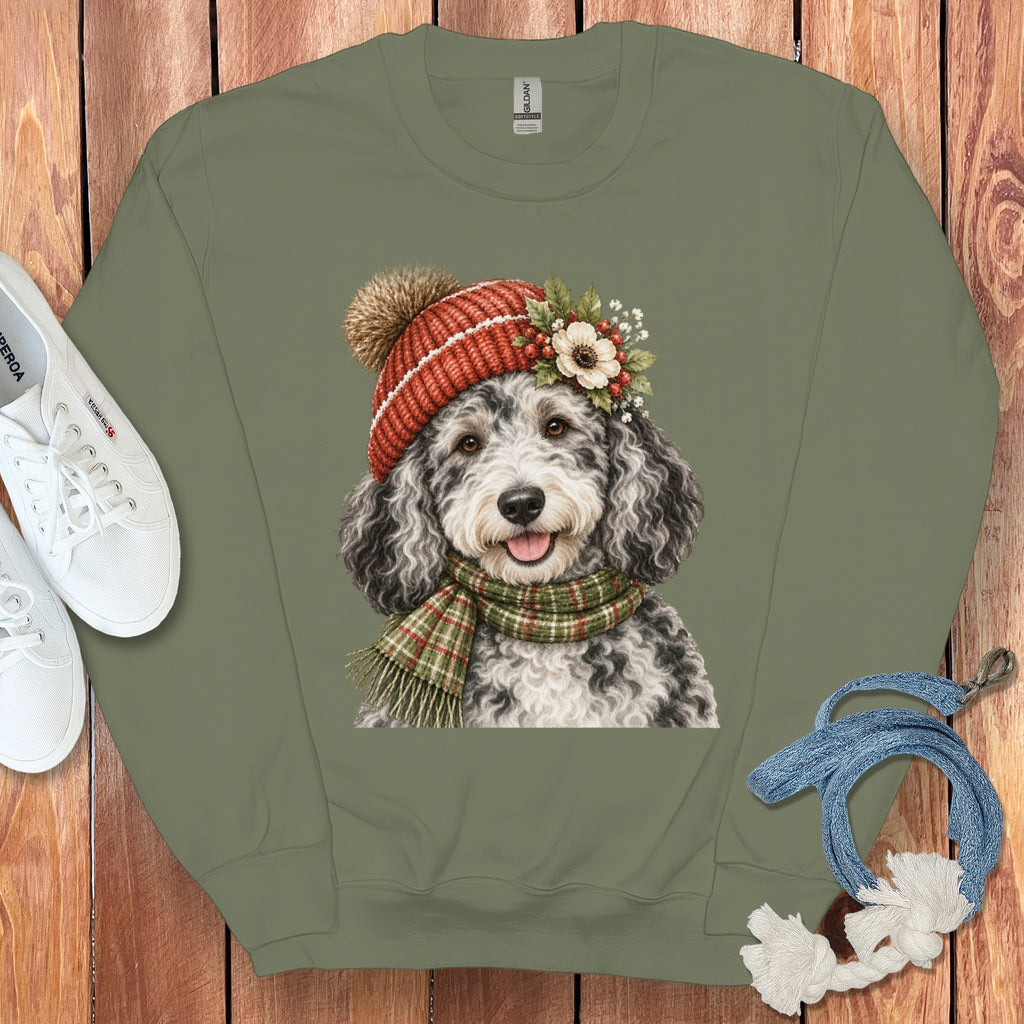 Sweatshirt with a black and white doodle wearing a red pom-pom hat and scarf.