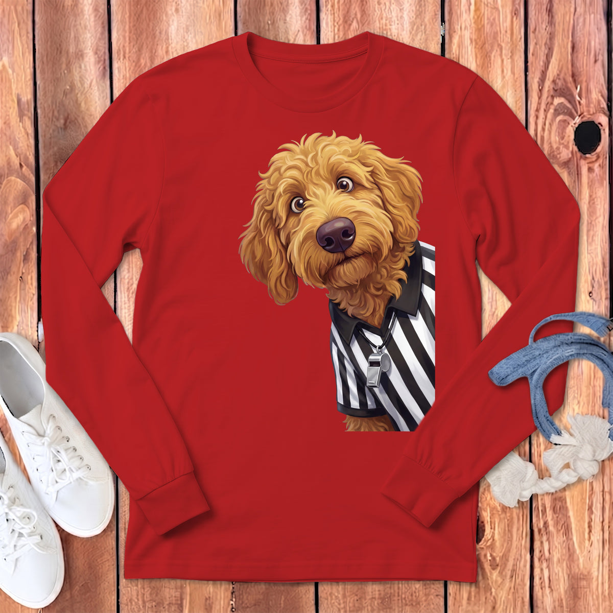 Golden doodle wearing a black and white striped referee shirt and a whistle.