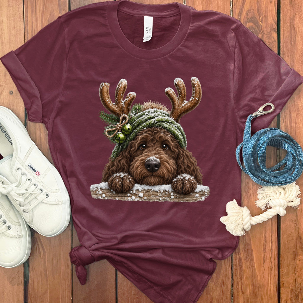 Maroon t-shirt with a doodle dog wearing a knit hat with antlers and bells.