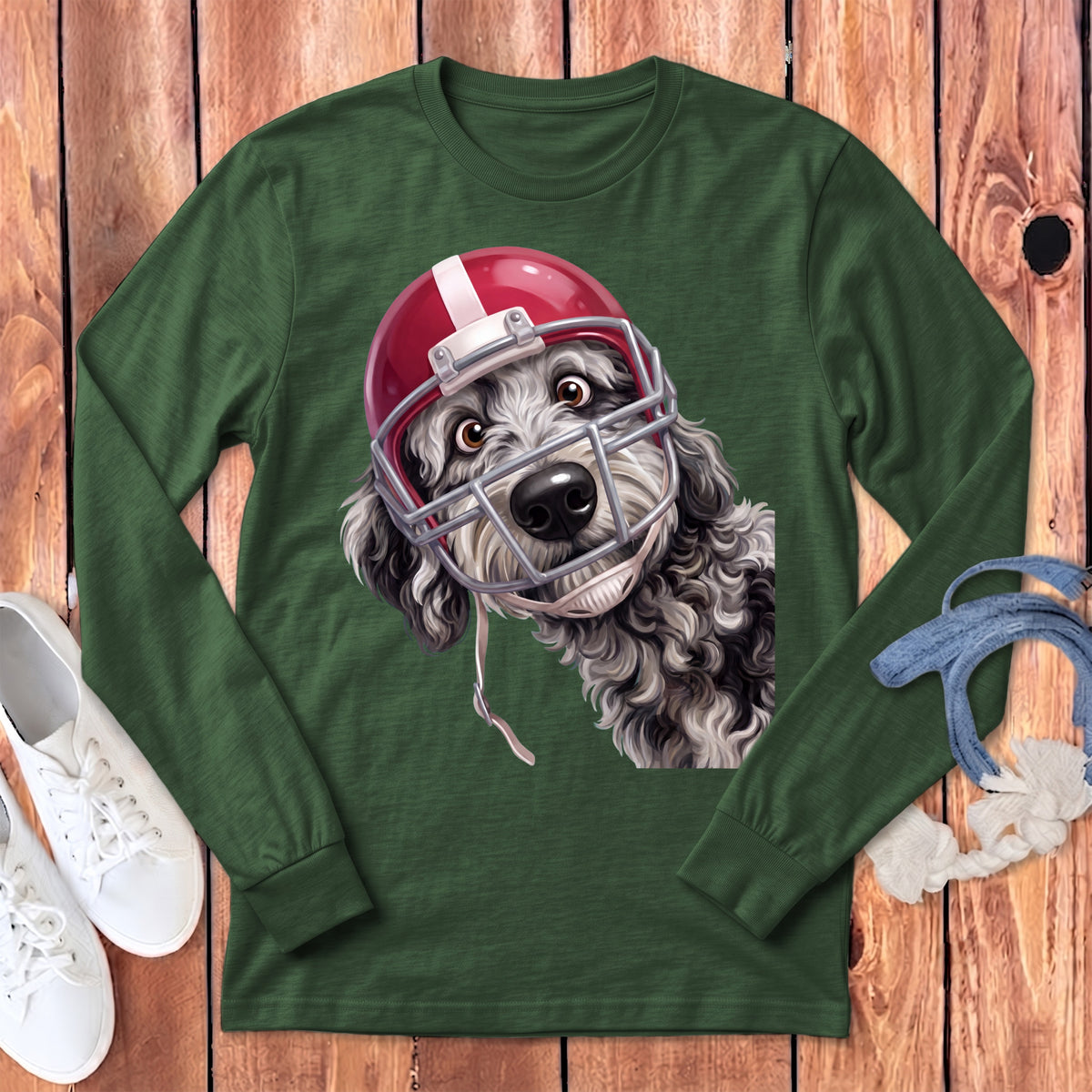A dark green long-sleeve t-shirt featuring a fluffy dog wearing a red football helmet.