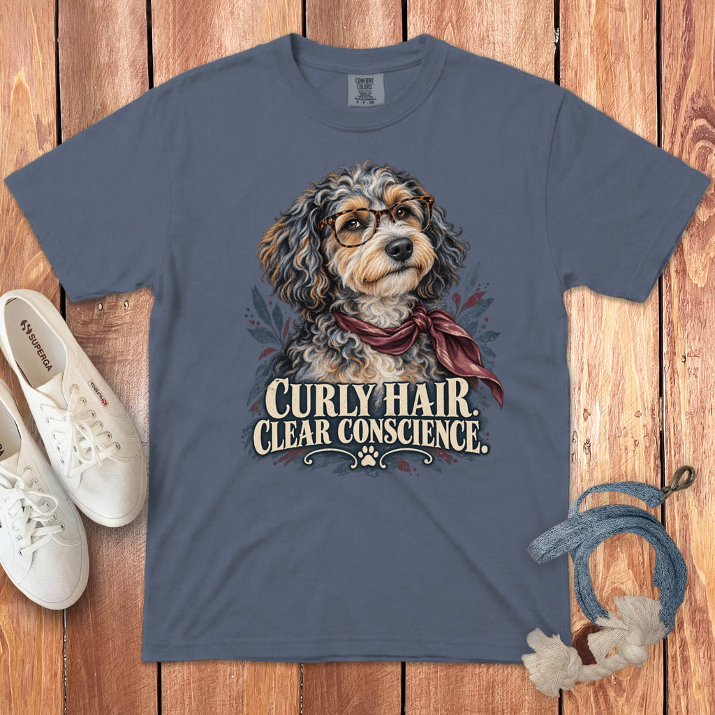Slate blue t-shirt featuring a doodle dog wearing glasses and a red scarf with text reading CURLY HAIR CLEAR CONSCIENCE.