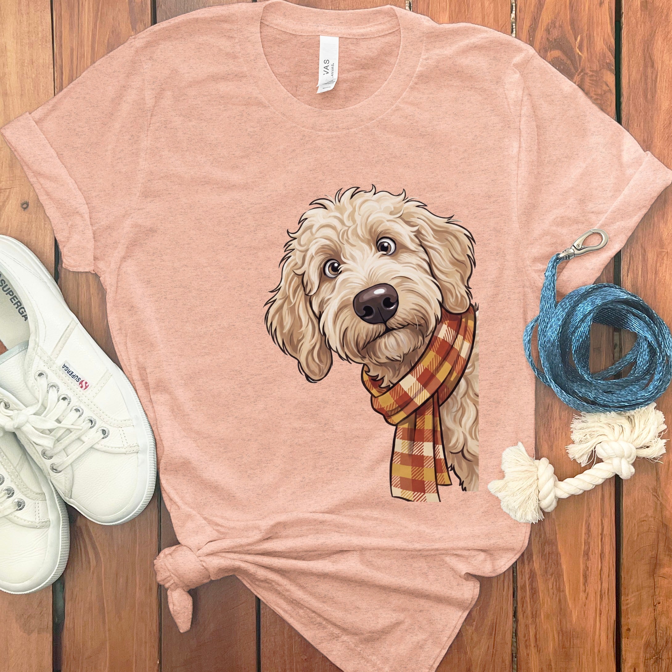 T-shirt with a cartoon drawing of a light-colored dog wearing a plaid scarf.