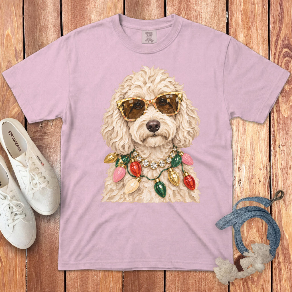 Pink t-shirt with a doodle wearing sunglasses and a string of colorful Christmas lights.