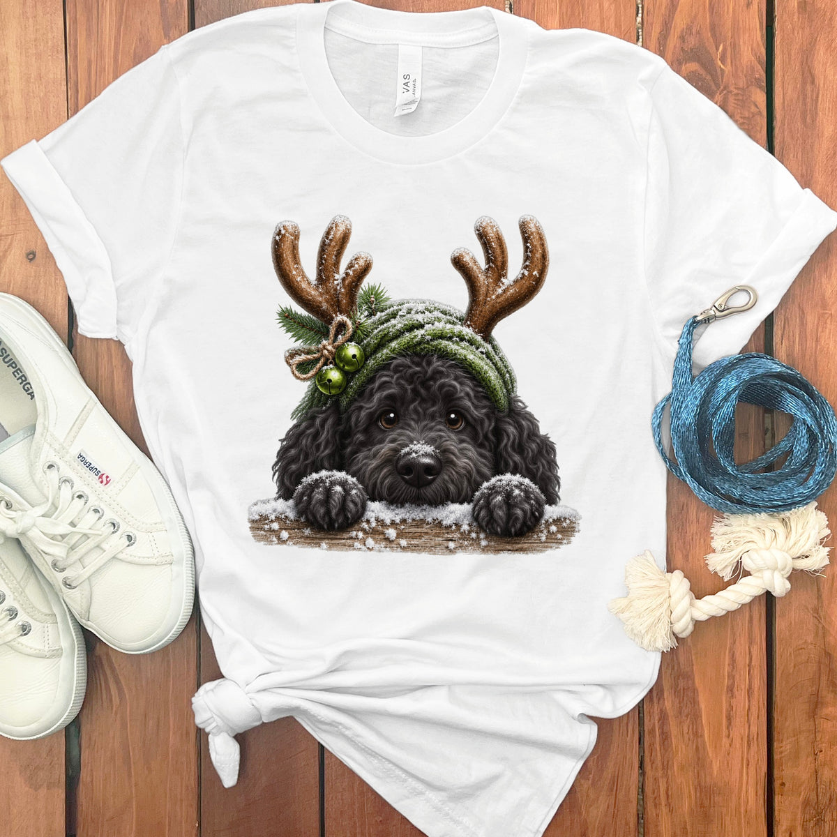 Black dog wearing a green knitted hat with antlers, bells, and pine sprigs.