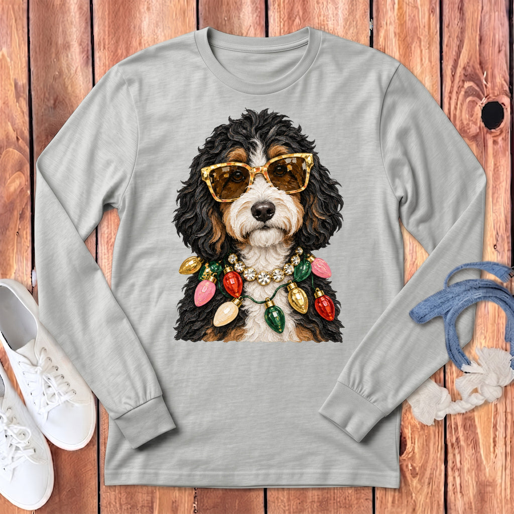 Bernedoodle wearing sunglasses and Christmas lights on a light gray long-sleeve shirt.