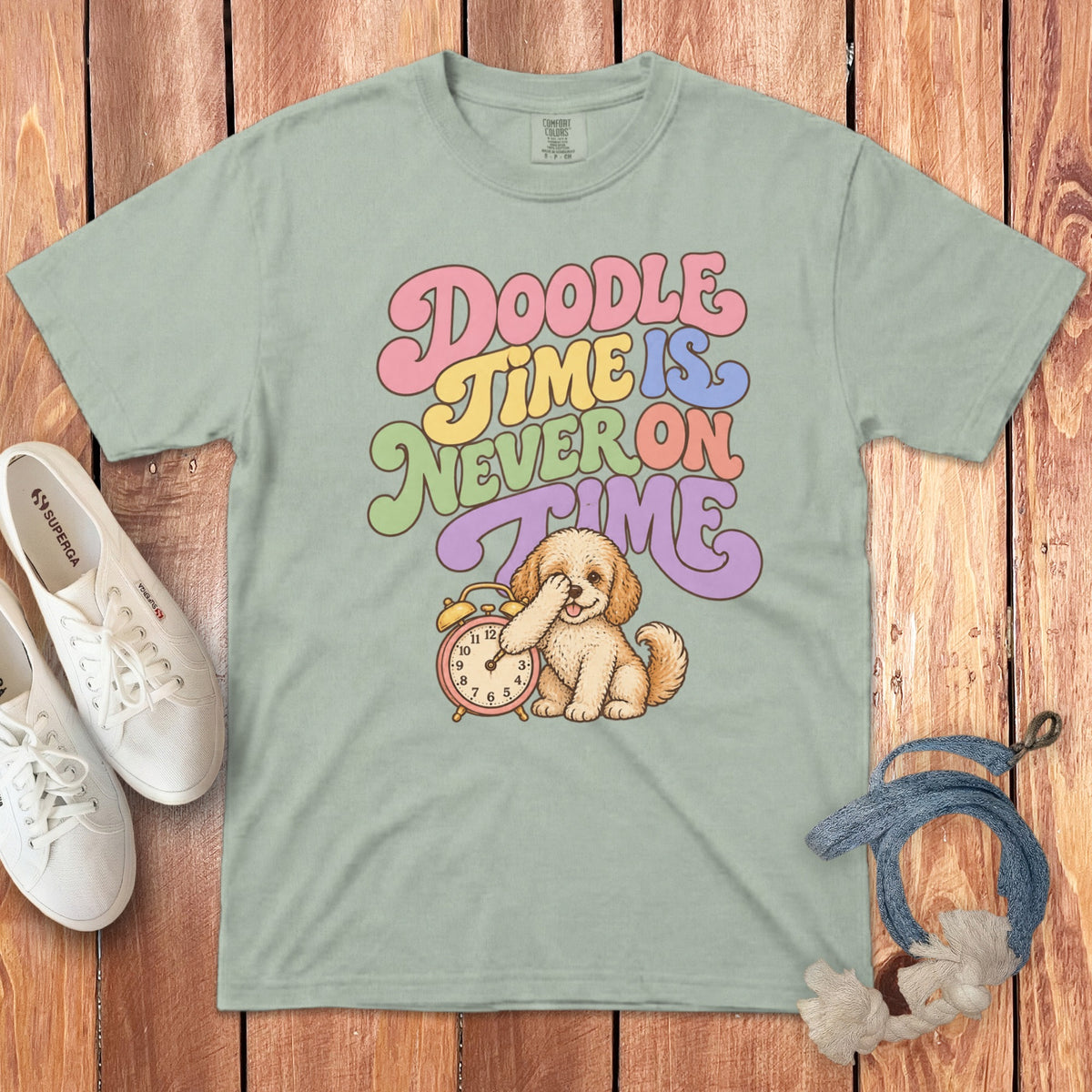 Light green t-shirt with retro text reading "Doodle Time Is Never On Time" and a puppy beside an alarm clock.
