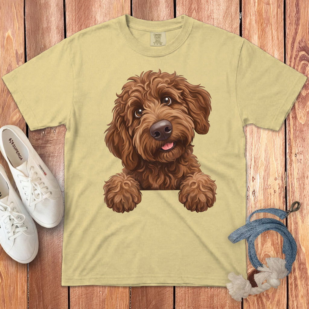 Light yellow t-shirt with a drawing of a brown doodle dog with paws over a hidden edge.