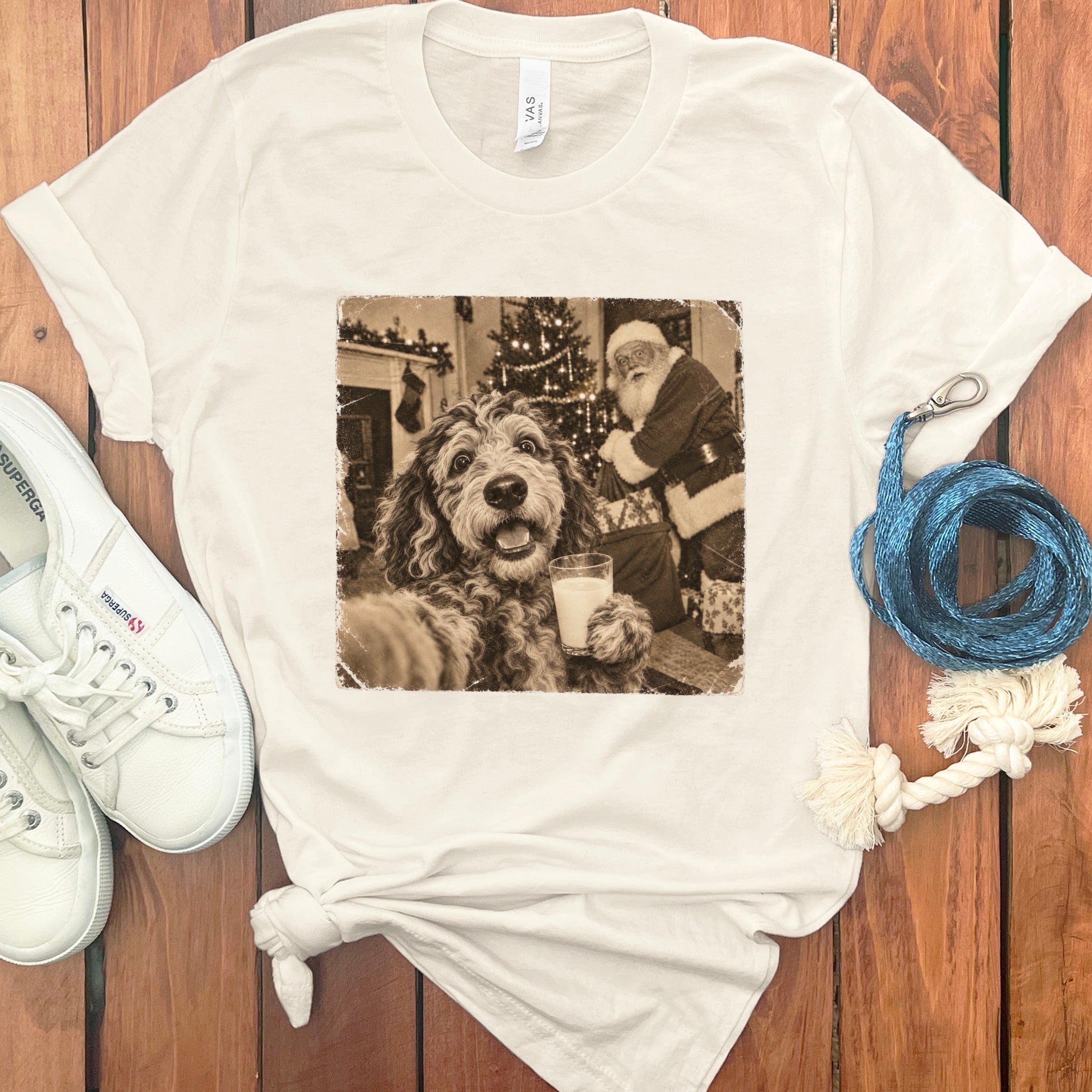 A white t-shirt featuring a vintage sepia graphic of a dog holding a glass of milk with Santa in the background.