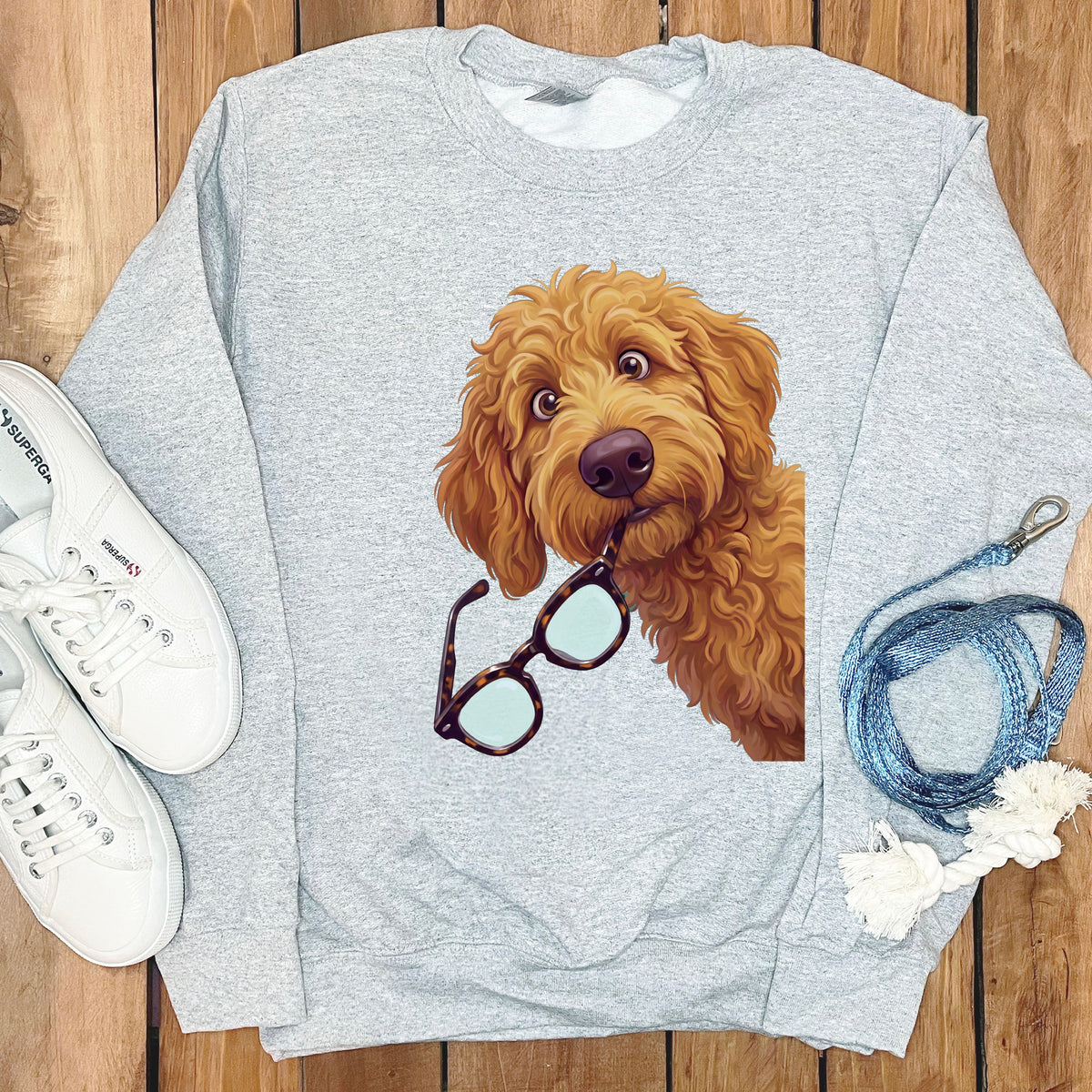 Light gray crewneck sweatshirt featuring a graphic of a golden fluffy dog holding glasses in its mouth.