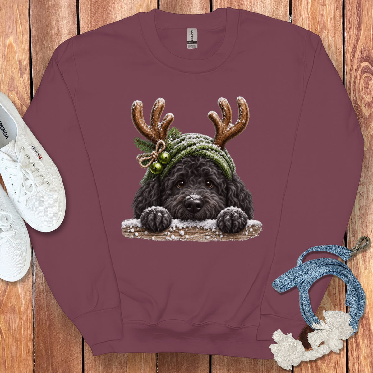 Maroon sweatshirt with a black dog wearing antlers and a green hat with jingle bells.